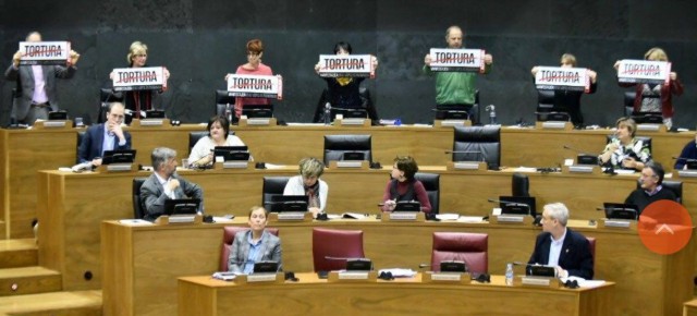 Los parlamentarios de Bildu exponiendo carteles en el turno de intervención del PPN