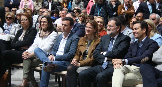 Rajoy escucha la intervención de Ana Beltrán